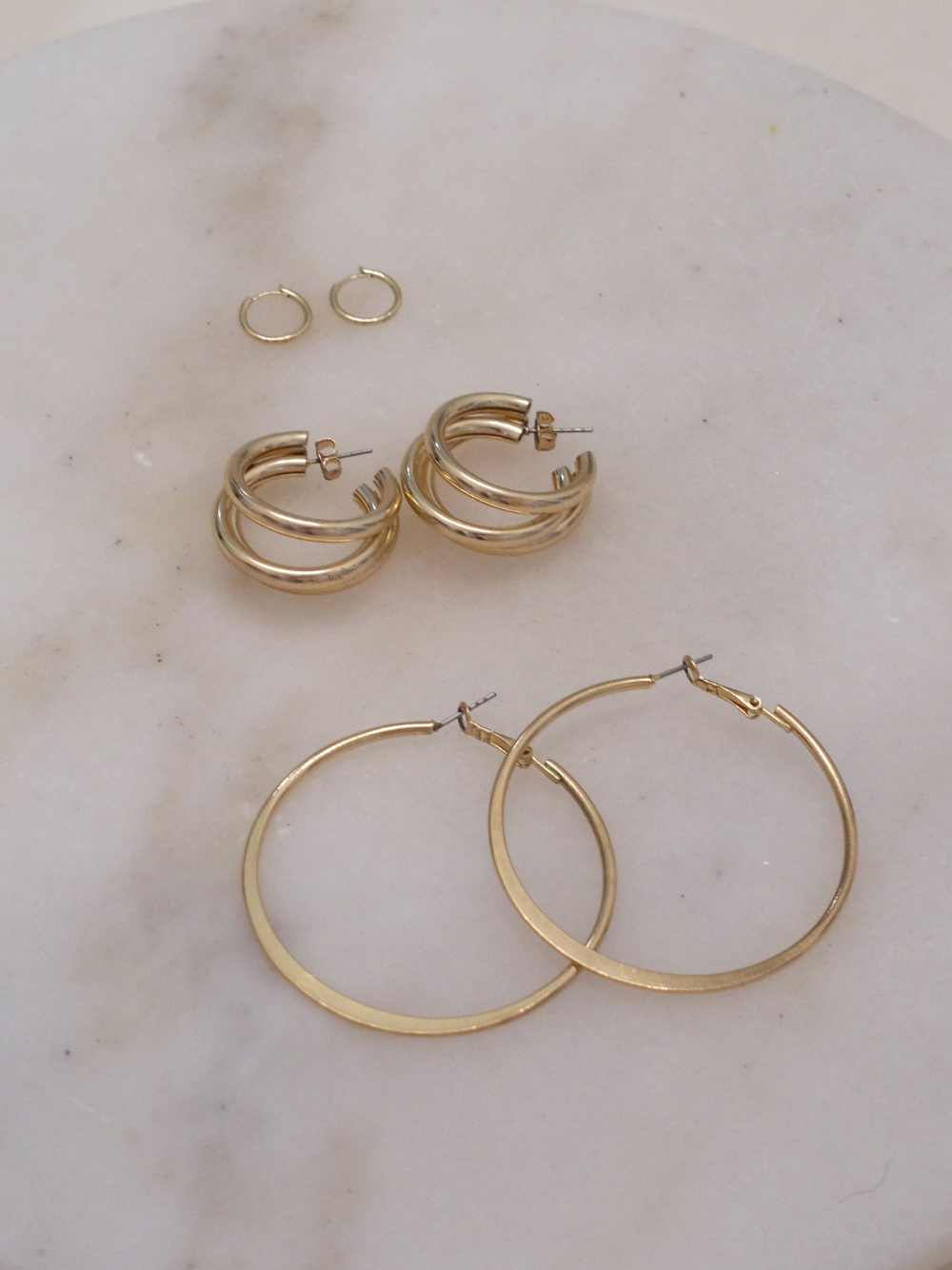 gold hoop earrings on marble