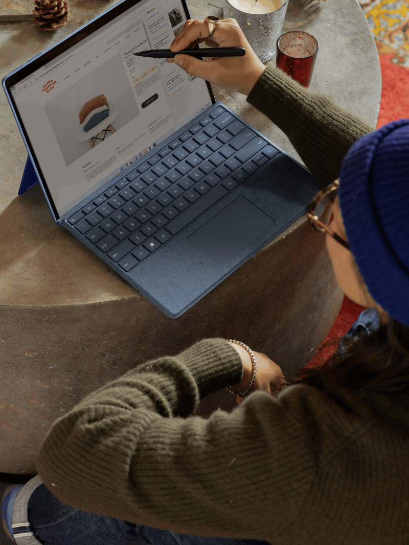woman working on a laptop sitting on the floor next to a concrete coffee table