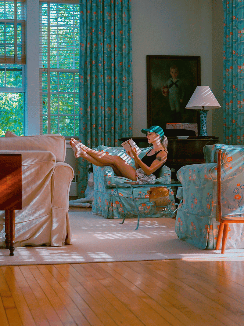 how to be an interesting woman reading on an armchair
